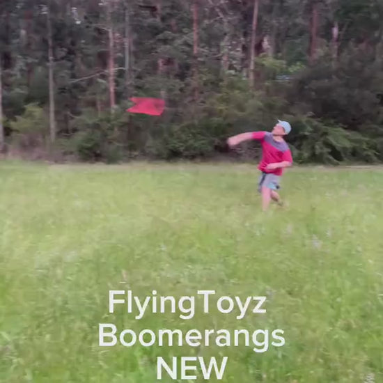 young man throwing the FlyingToyz Captain Hook aviation birch wooden boomerang that he catches
