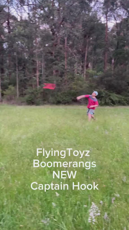 young man throwing the FlyingToyz Captain Hook aviation birch wooden boomerang that he catches