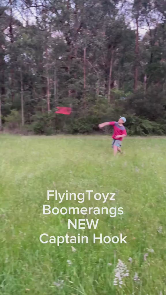 young man throwing the FlyingToyz Captain Hook aviation birch wooden boomerang that he catches